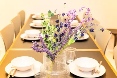 a table with a vase with purple flowers in it at Seven's Inn Takaramachi in Tokyo