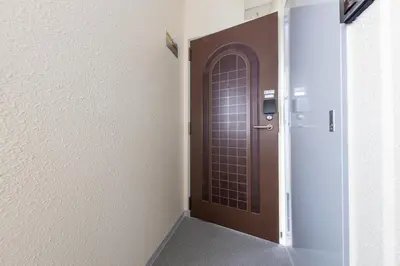 a hallway with a brown door and a stairway at \u3077\u3075\u304b\u9580\u524d\u4ef2\u753a Pufuka Monzennakacho in Tokyo