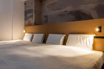 a bedroom with a large bed with white sheets and pillows at \u3077\u3075\u304b\u9580\u524d\u4ef2\u753a Pufuka Monzennakacho in Tokyo