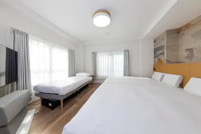 a white bedroom with two beds and a tv at \u3077\u3075\u304b\u9580\u524d\u4ef2\u753a Pufuka Monzennakacho in Tokyo