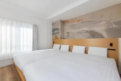 a bedroom with a large bed with white sheets at \u3077\u3075\u304b\u9580\u524d\u4ef2\u753a Pufuka Monzennakacho in Tokyo
