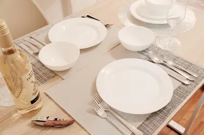 a table with white plates and silverware on it at Setagaya Quiet Residential Apartment203 in Tokyo