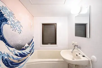 a bathroom with a painting of a wave on the wall at \u99c5\u5f92\u6b691\u5206 \u6210\u7530\u7a7a\u6e2f\u304b\u3089\u76f4\u901a\u99c5 \u7fbd\u7530\u7a7a\u6e2f\u304b\u3089\u76f4\u901a\u99c5 THE\u6771\u4eac\u548c\u98a8\u8cb8\u5207\u65c5\u9928 \u8fd1\u30b9\u30ab\u30a4\u30c4\u30ea\u30fc\u6d45\u8349\u4e0a\u91ce\u9280\u5ea7\u30c7\u30a3\u30ba\u30cb\u30fc 86\u30a4\u30f3\u30c1\u6620\u753bTV\u5ba4 \u9ad8\u901f\u5149Wifi \u9577\u671f\u5272\u5f15 \u516b\u5e83N01 in Tokyo