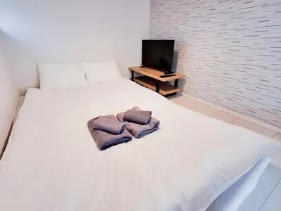 a bedroom with a white bed with towels on it at Triphome Otsuka 4 mins ShinOtsuka Station Loft bed in Tokyo