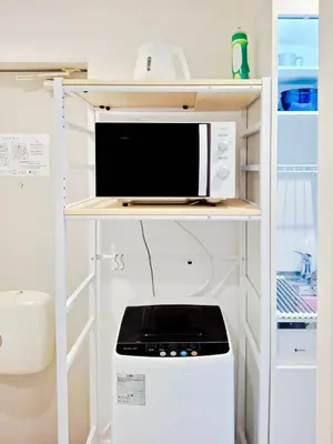 a microwave oven sitting on a shelf in a kitchen at Triphome Otsuka 4 mins ShinOtsuka Station Loft bed in Tokyo