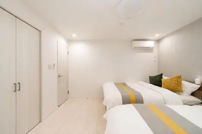 two beds in a bedroom with white walls at Alice \u65e5\u66ae\u91cc \u5c71\u624b\u7ebf\u6b65\u884c6\u5206\u949f \u6210\u7530\u76f4\u8fbe \u4e0a\u91ceAsakusa\u76f4\u8fbe \u6574\u5957\u5bb6\u5ead\u623f in Tokyo