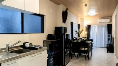 a kitchen with a sink and a table with chairs at Kasai disney access hotel in Tokyo