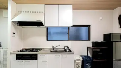 a kitchen with white cabinets and a sink at Kasai disney access hotel in Tokyo