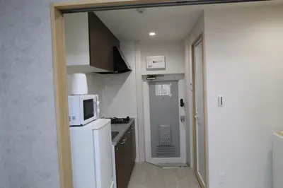 a small kitchen with a white refrigerator and a microwave at M15 Aoba Great location within walking distance of Ikebukuro in Tokyo