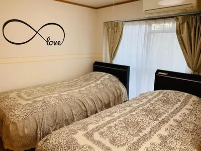 two beds in a room with a sign that says love at HOTEL k &m in Tokyo