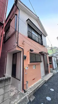 a building with a door and a balcony on a street at Mori Hosue \u8d64\u7fbd\u5357 in Tokyo