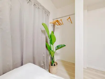 a plant in a vase in a room with a curtain at Mori Hosue \u8d64\u7fbd\u5357 in Tokyo