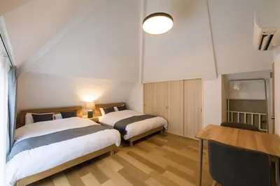 a bedroom with two beds and a table and a desk at Shinjuku 6-chome City Stay 4F \u65b0\u5bbf6\u4e01\u76ee \u30b7\u30c6\u30a3\u30b9\u30c6\u30a4 4F in Tokyo