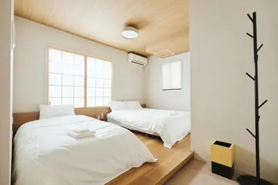 a bedroom with two beds and a window at \u82e5\u8449\u30db\u30c6\u30eb in Tokyo