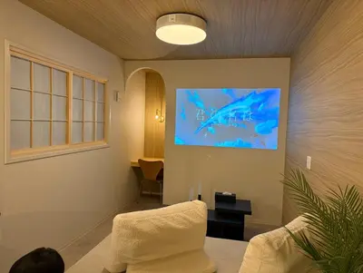 a living room with a couch and a painting on the wall at \u82e5\u8449\u30db\u30c6\u30eb in Tokyo