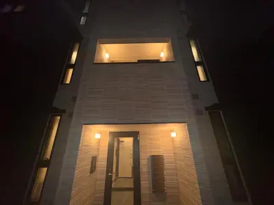 a tall brick building with lights on it at night at Nexus Villa Morishita in Tokyo