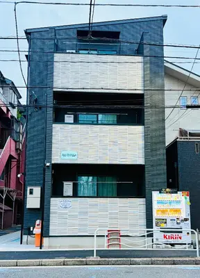 a tall building with a sign in front of it at Nexus Villa Morishita in Tokyo