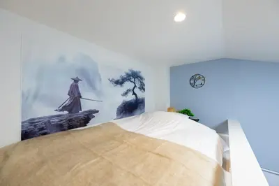 a bedroom with a bed with a painting on the wall at Tsumugi Yado \u5927\u4e45\u4fdd \u30de\u30f3\u30b9\u30ea\u30fc \u30ed\u30f3\u30b0\u30b9\u30c6\u30a4 in Tokyo