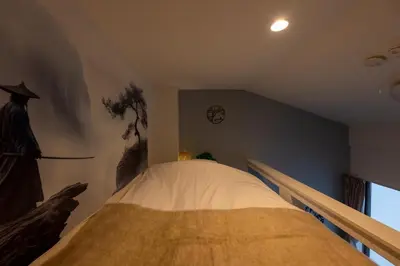 a bedroom with a bed with a statue of a man at Tsumugi Yado \u5927\u4e45\u4fdd \u30de\u30f3\u30b9\u30ea\u30fc \u30ed\u30f3\u30b0\u30b9\u30c6\u30a4 in Tokyo