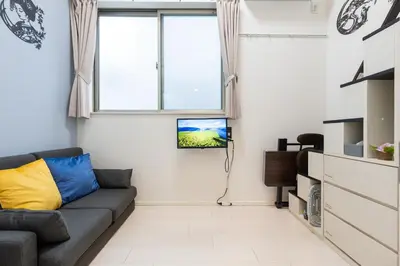 a living room with a couch and a window at Tsumugi Yado \u5927\u4e45\u4fdd \u30de\u30f3\u30b9\u30ea\u30fc \u30ed\u30f3\u30b0\u30b9\u30c6\u30a4 in Tokyo