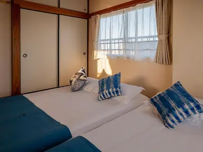 a bedroom with a bed with pillows and a window at \u685c\u306e\u5ddd79 \u5317\u5343\u4f4f\u5bb6\u5ead\u516c\u5bd36-8\u4eba\u4e28Kita Senju family apartments for 6-8 people in Tokyo