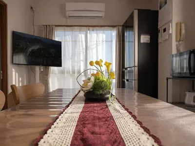 a table with a vase of flowers on top of it at \u685c\u306e\u5ddd79 \u5317\u5343\u4f4f\u5bb6\u5ead\u516c\u5bd36-8\u4eba\u4e28Kita Senju family apartments for 6-8 people in Tokyo