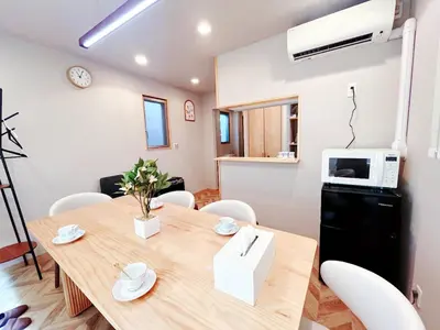 a dining room with a table and a microwave at \u6d45\u8349\u6a4b\u99c5\u8fd1 \u4ea4\u901a\u4fbf\u5229 8\u540d\u53ef\u5e83\u3005\u4e00\u8ed2\u5bb6 \u4eba\u6c17\u89b3\u5149\u5730\u8fd1\u304f \u79cb\u8449\u539f \u6d45\u8349 \u9280\u5ea7\u81f3\u8fd1 in Tokyo
