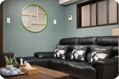 a black leather couch in a living room with a mirror at Alice Room\u677f\u6a4b501 in Tokyo