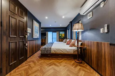 a bedroom with a bed and a lamp on a wooden floor at tsukiji 2min,V301,Ginza 10min in Tokyo