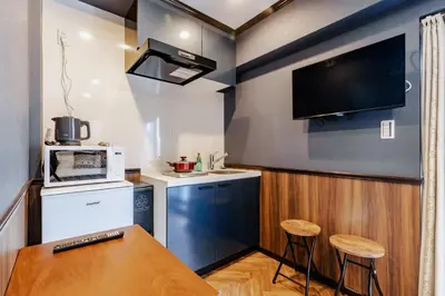 a kitchen with a table and a tv on the wall at tsukiji 2min,V301,Ginza 10min in Tokyo