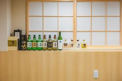 a row of bottles of alcohol sitting on a counter at tsukiji 2min,V301,Ginza 10min in Tokyo