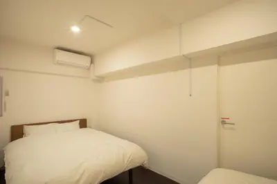 a small bedroom with a bed and a window at NIYS apartments 74type in Tokyo