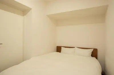a white bed with two pillows in a room at NIYS apartments 74type in Tokyo