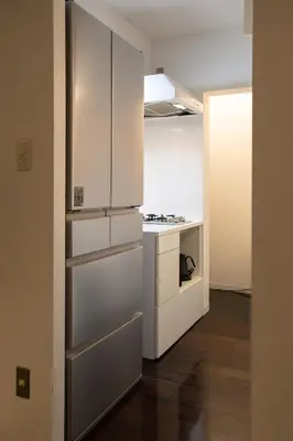 a kitchen with white cabinets and a stove at NIYS apartments 74type in Tokyo