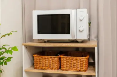 a microwave sitting on top of a shelf with baskets at Lions Mansion SHIBUYA 219 in Tokyo