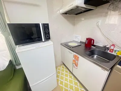 a small kitchen with a sink and a microwave at happy home 102\u5ba4\u65b0\u5927\u4e45\u4fdd\u65b0\u5bbf\u30a8\u30ea\u30a2 in Tokyo