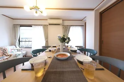 a long wooden table with chairs and a bowl of food at ever Inn Higashi koenji in Tokyo