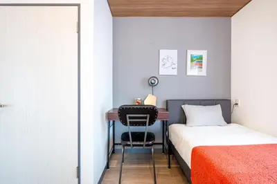 a small bedroom with a desk and a bed at HanaStay-Tokyo Ueno 2 Stops in Tokyo