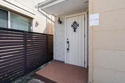 a house with a white door and a fence at Vacation Stay Koiwa in Tokyo
