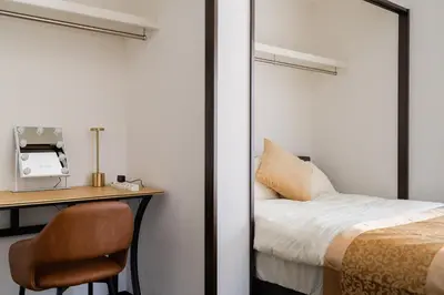 a bedroom with a bed and a desk with a chair at Vacation Stay Koiwa in Tokyo