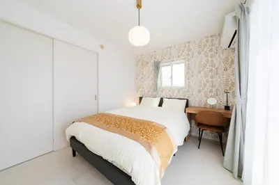 a white bedroom with a bed and a desk at Vacation Stay Koiwa in Tokyo