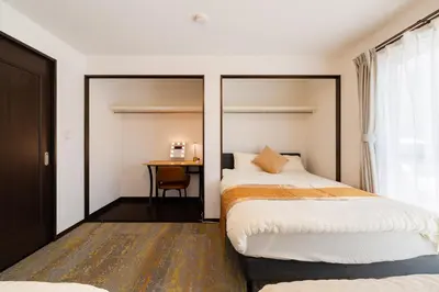 a bedroom with two beds and a desk at Vacation Stay Koiwa in Tokyo