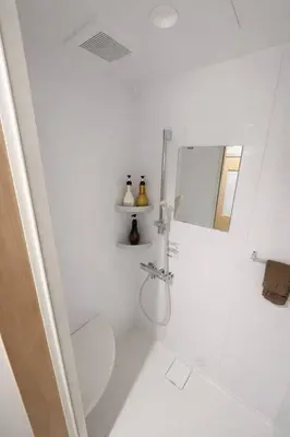 a white bathroom with a shower and a toilet at Kukunochi in Tokyo
