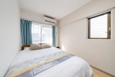 a bedroom with a large bed and a window at Shinjuku,Higashi Shinjuku Sta, 5min walk,WiFi in Tokyo