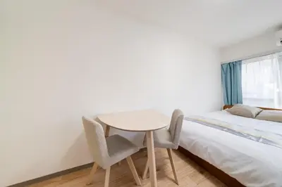 a bedroom with a table and chairs next to a bed at Shinjuku,Higashi Shinjuku Sta, 5min walk,WiFi in Tokyo