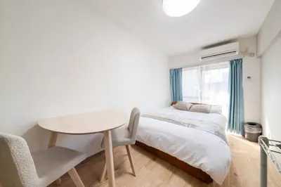 a bedroom with a bed and a table and chairs at Shinjuku,Higashi Shinjuku Sta, 5min walk,WiFi in Tokyo