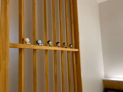 a wooden shelf with dolls on a wall at \u4e0b\u753a\u65b0\u5c0f\u5ca9\u7f8e\u5e78\u30cf\u30a6\u30b9101 in Tokyo