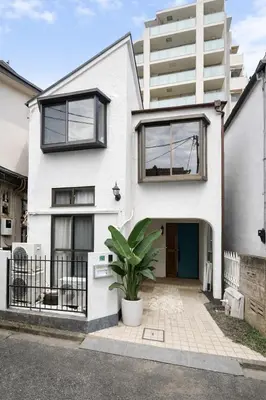 a white house with a plant in front of it at KiMura in Tokyo