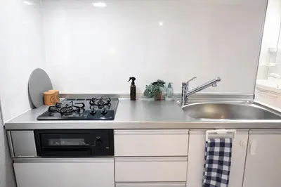a kitchen with a stove top oven next to a sink at KiMura in Tokyo