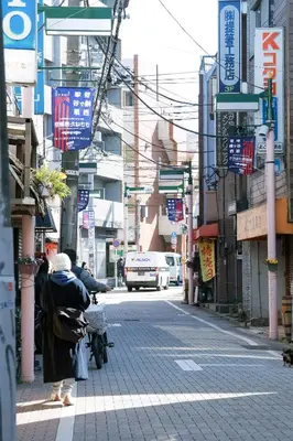 an old woman sitting on a bench on a city street at SunRiseStay Shibuya\u6da9\u8c37 in Tokyo